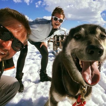 a man and a dog sitting in the snow